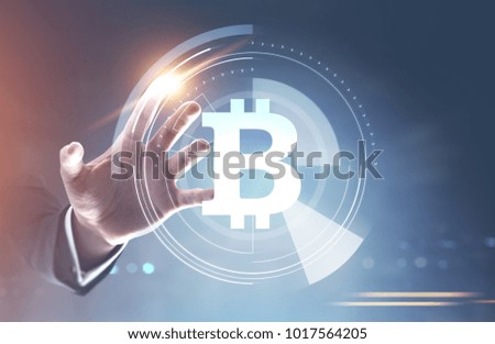 Unrecognizable businessman hand interacting with a bitcoin HUD, infographics and immersive interface against a blurred background. Toned image double exposure mock up