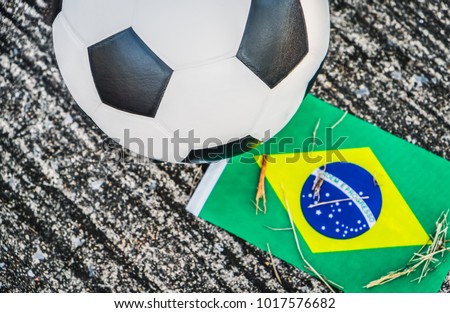 Classic leather soccer ball on the ground with Brazil national team flag of the participating country in the championship tournament with copy space. World cup concept Royalty-Free Stock Photo #1017576682