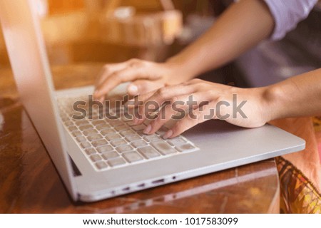 Freelance woman's hands on the keyboard laptop computer in a cafe, girl using laptop typing, web searching, browsing / soft focus image.