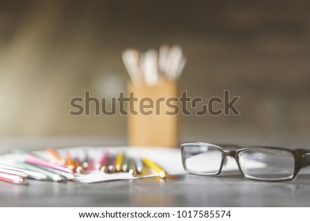 Close up of eyeglasses and supplies on blurry background 