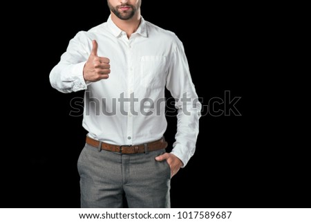 cropped view of businessman in white shirt showing thumb up, isolated on black