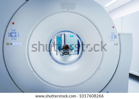 Female patient undergoing CT - Computerized Tomography Scan in Hospital. Patient wearing lead apron to   cover vital organs. View through the tube of the device. Royalty-Free Stock Photo #1017608266