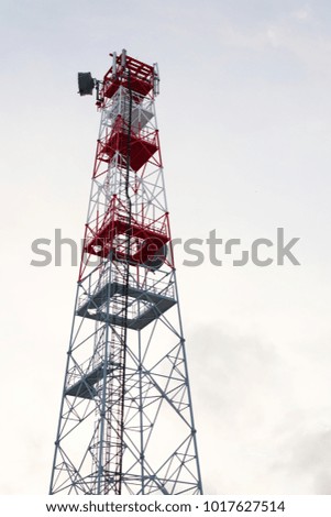 Transmitters and aerials on telecommunication tower, sunset in snowy country