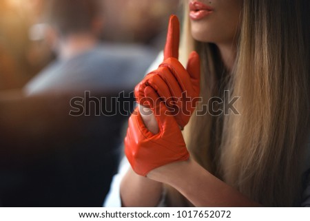 A girl in leather gloves in a cafe. Hands in the foreground in gloves.
