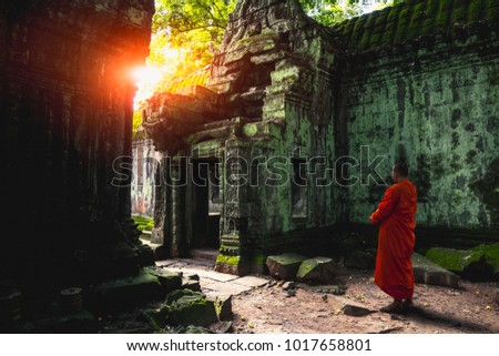 Buddhist monk at Angkor Wat ancient khmer architecture Ta Prohm temple ruins hidden in jungles, Cambodia Royalty-Free Stock Photo #1017658801