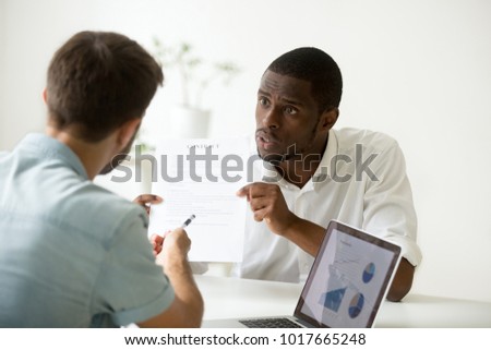 Disgruntled angry african businessman arguing disagreeing about business contract loan fraud, dissatisfied black investor having dispute with white partner pointing at document breaking agreement Royalty-Free Stock Photo #1017665248
