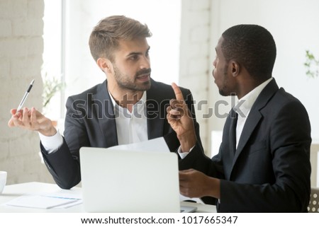 African black client having claims about business document disagreeing with caucasian partner, stressed diverse businessmen arguing in office disgruntled by bad contract or obligations noncompliance Royalty-Free Stock Photo #1017665347
