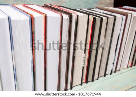 Pile of various books on bright wooden background. With copy space for your text