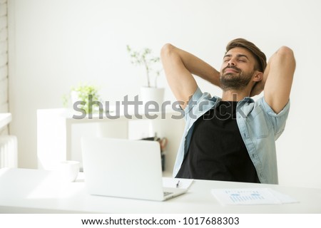 Relaxed young man resting from work on laptop holding hands behind head, successful entrepreneur relaxing feels happy breathing fresh air, smiling man enjoy break stretching in home office workplace Royalty-Free Stock Photo #1017688303