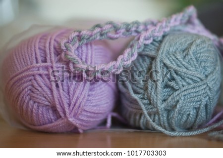 Close up colorful yarn texture background, violet and gray strains. Shallow depth of focus. Knitting and crochet, craft work concept. Winter clothes. Color combination for styling.