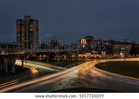 BURGAS, BULGARIA - FEBRUARY 1, 2018: Overhead pedestrian bridge at night. McDonald's restaurant logo.