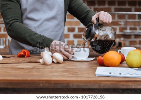 cropped image of man pouring coffee into cup