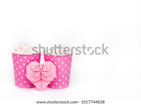 Two paper cups and valentine on white background. Cocoa, marshmallow and paper heart. Romantic concept. St. Valentine's Day. Copy space