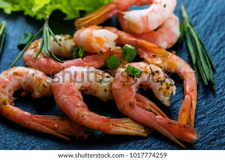 Cooked shrimps, prawns  with seasonings on dark stone background