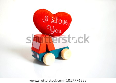 Wooden car carrying red heart with message  I Love you for Valentines day on white background.