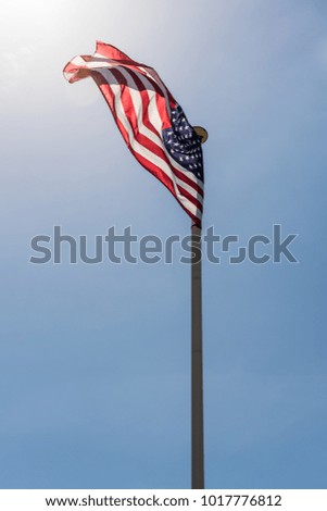 American flag waving in the wind with blue sky