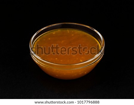 Sweet and sour sauce on black background 