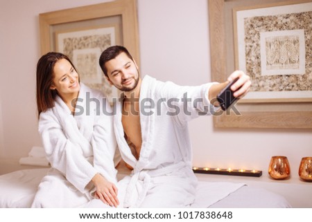 Couple in love enjoying wellness weekend and taking selfies in spa salon