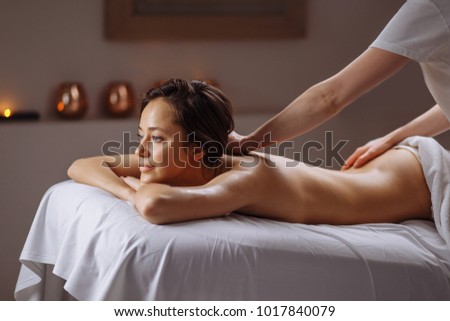 Beautiful woman receiving a relaxing back massage at spa. Royalty-Free Stock Photo #1017840079