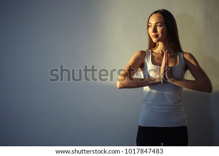 woman practicing yoga, holding palms together in namaste mudra, relaxed and peaceful.
