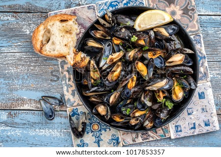 Traditional barbecue Italian blue mussel in white wine as top view in a casserole  Royalty-Free Stock Photo #1017853357