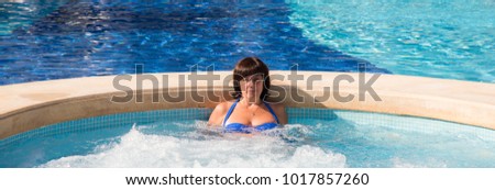 middle-aged brunette woman in blue water pool blue bathing suit on vacation