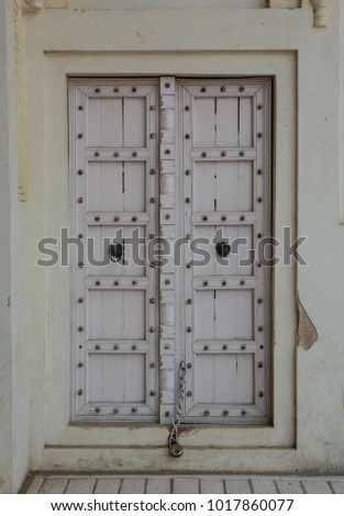 Wooden door and ornament on wall of ancient fort in Agra, India.