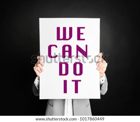 A woman holding a we can do it placard