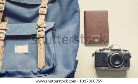 long holiday travel flat lay concept from blue backpack and lather strap for man with retro camera and passport 