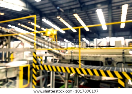 Industry technology trend concept. Blur automation conveyor belt machine with yellow and black color alert safety sign in smart factory manufacturing operation for background.
