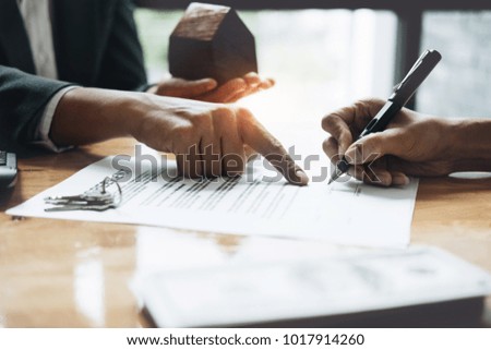 Businessman and estate agent signing a document for house deal, vintage filter effect