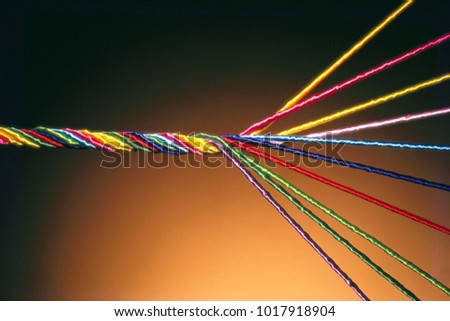 COLOURFUL THREADS OF SILK/SATIN UNWINDING FROM A SINGLE THREAD. THIS HAS BEEN SHOT ON FILM AND SCANNED Royalty-Free Stock Photo #1017918904