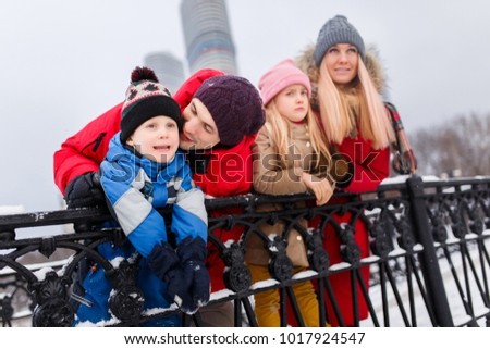 Picture of happy parents with daughter and son on winter walk