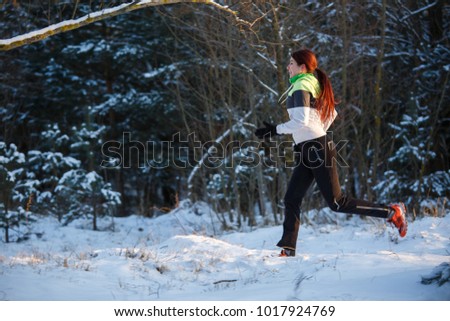 Image of young athlete running through winter forest