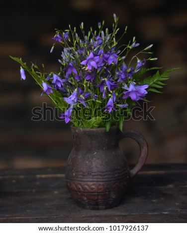field flowers bells in a ceramic jug