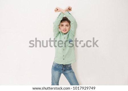 Handsome smiling child making victory gesture. Concept of childhood and fashion