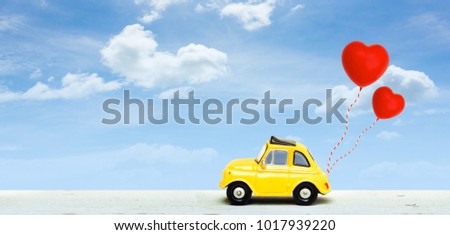 Miniature car with two red heart balloon. concept of love  wedding honeymoon