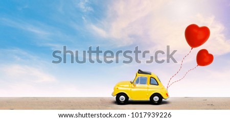 Miniature car with two red heart balloon. concept of love  wedding honeymoon