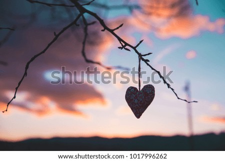 Silhouette of heart, beautiful colorful sunset sky in background