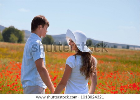 Couple walking in field of poppies