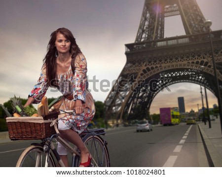 Woman riding bicycle under Eiffel Tower