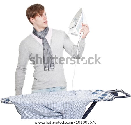 young man completely overwhelmed with his laundry and the electric iron  - isolated on white background