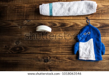 a soap towel and loofah on wooden background