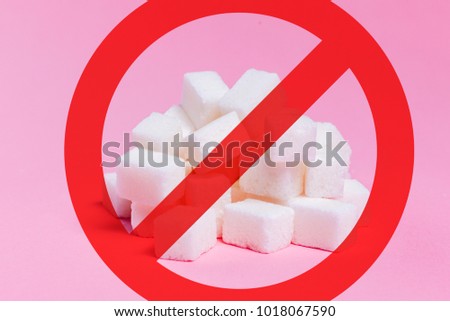 Sugar cubes crossed a red stripe in the circle as a prohibiting road sign. Pink background