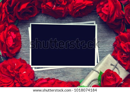 blank photo card in frame made of red roses flowers and gift box. mock up. flat lay. top view. valentines day background. vintage toning