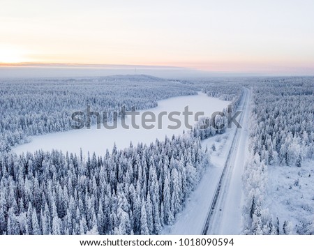 Road through winter wonderland in Finnish Lapland. Winter scenery. Landscape photo captured with drone above winter wonderland.