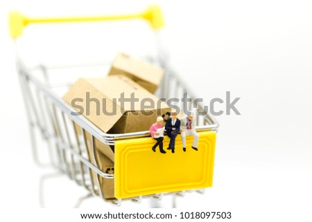 Miniature people: Group businessman sitting on shopping cart for retail business. Image use for online and offline shopping, marketing place world wide.
