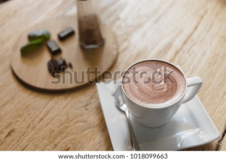Top view cup of hot coffee latte art heart-shaped wooden floor.