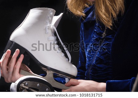 young girl in hat with skates for ice-skating