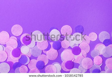 Trendy lilac confetti on pastel pink background. Festive background  for your design.
